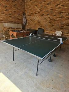 a ping pong table in a room with a brick wall at The Ducks - Gorgeous Norfolk Upside down Cottage - with Lazy Spa in Mileham