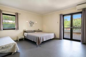 a bedroom with two beds and a large window at Prostorni in udobni apartmaji Izola SL - Spacious & Comfortable Apartments Izola SL in Izola