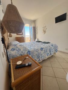 a bedroom with a bed and a table with a remote control at B&B Santa Maria Di Leuca in Leuca