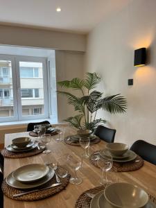 a dining room table with plates and wine glasses at Residentie Sweetnest met hotelservice à la carte - 3 dubbel kamers in Knokke-Heist