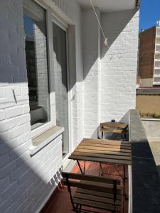a picnic table and a bench on a patio at Residentie Sweetnest met hotelservice à la carte - 3 dubbel kamers in Knokke-Heist