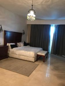 a bedroom with a large bed and a chandelier at Carlton Luxury Villa in Sharm El Sheikh +31 photos