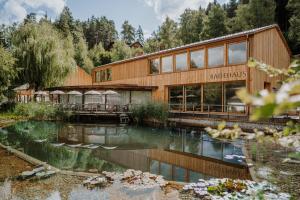 a building with a pond in front of it at Naturhotel Saalerwirt in San Lorenzo di Sebato