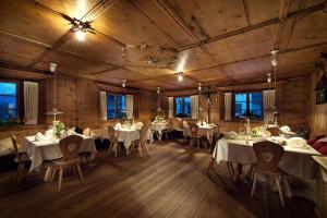 a dining room with white tables and chairs at Naturhotel Saalerwirt in San Lorenzo di Sebato