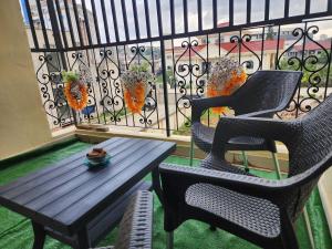 two chairs and a wooden table on a balcony at Le nid des Anges in Yaoundé