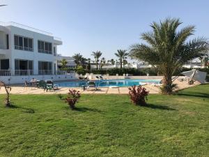 a resort yard with a swimming pool and palm trees at Carlton Luxury Villa in Sharm El Sheikh