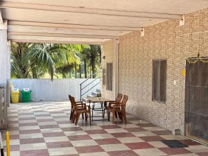 a patio with a table and chairs on a tile floor at Hamsa Farmstay - 3BHK AC homestay in Mysore