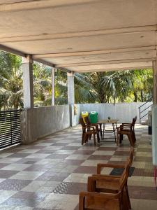 a patio with a table and chairs and trees at Hamsa Farmstay - 3BHK AC homestay in Mysore