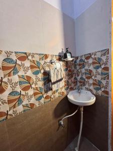 a bathroom with a sink and a tile wall at Hamsa Farmstay - 3BHK AC homestay in Mysore +19 photos