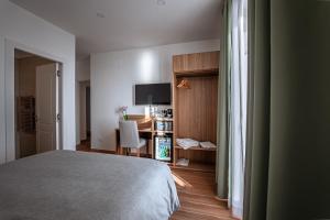 a bedroom with a bed and a desk and a television at 266 La Barraca in Torvaianica