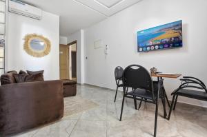 a living room with a couch and a table and chairs at White Majorelle Azul in Tamraght Ouzdar