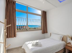 a bedroom with a window with a view of the beach at White Majorelle Azul in Tamraght Ouzdar