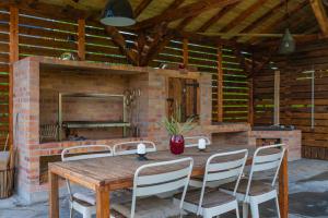 a patio with a wooden table and chairs and a fireplace at Staniszowska Przystań in Staniszów