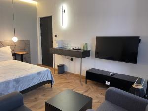 a bedroom with a bed and a flat screen tv at XIX Boutique Apartment in Skopje