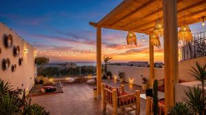 a rooftop patio with a view of the sunset at White Majorelle Azul in Tamraght Ouzdar