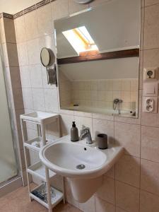 a bathroom with a sink and a mirror at Apartmán Silvia in Komárno