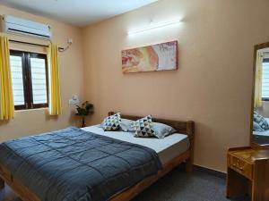 a bedroom with a bed with two pillows on it at Hamsa Farmstay - 2BHK AC Homestay in Mysore