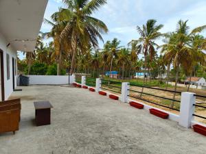 a building with a row of benches and palm trees at Hamsa Farmstay - 2BHK AC Homestay in Mysore
