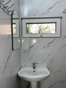 a bathroom with a sink and a mirror and a window at A frame house with a view of mountains in Karakol