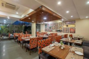 a restaurant with wooden tables and orange chairs at Zone Connect by The Park Katra in Katra