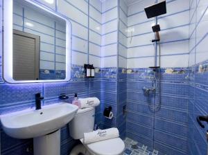 a blue tiled bathroom with a sink and a toilet at White Majorelle Horizon in Tamraght Ouzdar +105 photos