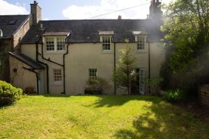 an old house with a grass yard in front of it at Snow Cottage, Old Aberdeen, 3 bedroom luxury in Aberdeen