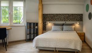 a bedroom with a large bed and two windows at Dworek Akacja in Janowiec +12 photos