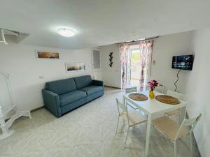 ein Wohnzimmer mit einem blauen Sofa und einem Tisch in der Unterkunft Marea - Immobilevante in Ponza