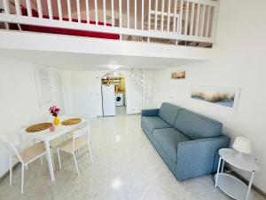 ein Wohnzimmer mit einem blauen Sofa und einem Tisch in der Unterkunft Marea - Immobilevante in Ponza