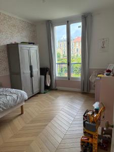 a room with a bedroom with a bed and a window at Grande maison familiale rénovée en 2025 in Versailles
