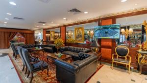 a lobby with couches and chairs and a television at Habitat All Suites, Al Khobar in Al Khobar