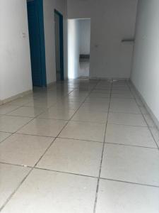 an empty room with a white tiled floor and blue doors at Maria imóveis in Trindade