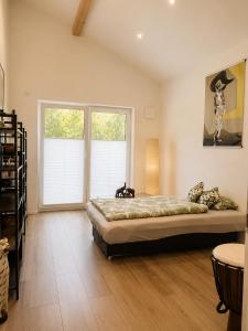 a bedroom with a large bed and two windows at Ferienwohnung 'Moseltraum' in Ensch