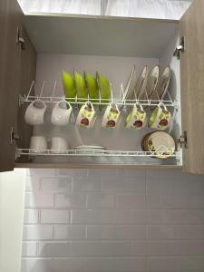 a kitchen with plates and bowls on a shelf at ApartahotelVacacionalSangil in San Gil