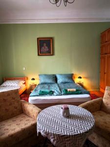 a bedroom with a bed and two chairs and a table at Retró Kúria in Fonyód