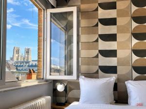 a bedroom with a window with a view of the city at Centerstay Brussels in Brussels