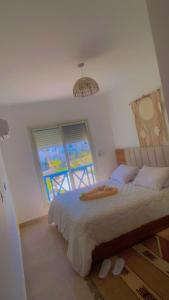 a bedroom with a bed and a large window at MV Ras El Hakma 190 A in Ras Elhekma