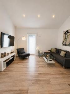 a living room with a couch and a tv at Ferienwohnung 'Moseltraum' in Ensch
