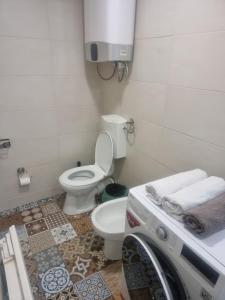 a bathroom with a toilet and a washing machine at Apartman Katedrala in Sarajevo +3 photos