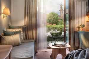a living room with a couch and a table and a window at Naturhotel Saalerwirt in San Lorenzo di Sebato