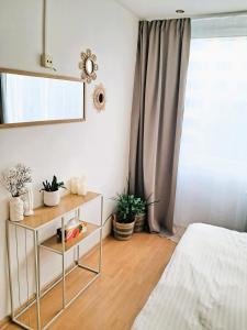 a bedroom with a mirror and a table with plants at Metro Budějovická apartment in Prague