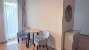 a table and four chairs in a room with a mirror at VillaAnita in Augustów