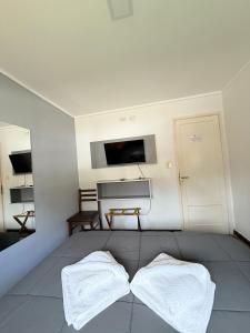 a bedroom with two white towels on a bed at Hotel Hermitage in Tandil