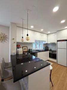 a kitchen with white cabinets and a black counter top at Casa da Linha in Caminha