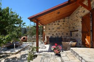 a stone house with a patio with a table and chairs at Blue Cottage in Apsiou