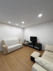 a living room with a couch and a tv at Casa da Linha in Caminha
