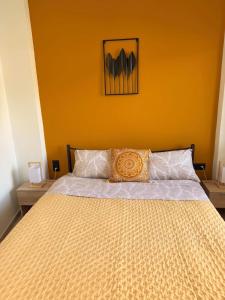 a bedroom with a large bed with a yellow wall at Nature Nest in Samos