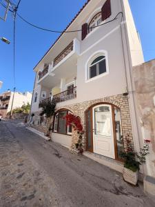 a white building with a door on a street at Nature Nest in Samos