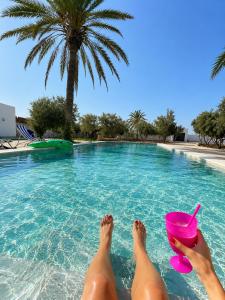 two people laying in the water in a swimming pool at Maison Ile d'Olive in Midoun