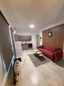 a living room with a red couch and a kitchen at Nature Nest in Samos